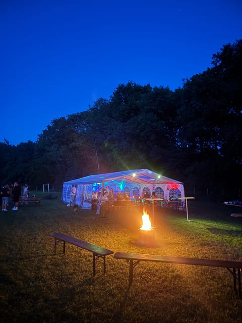 Feuerstelle vor einem bunt beleuchteten Festzelt